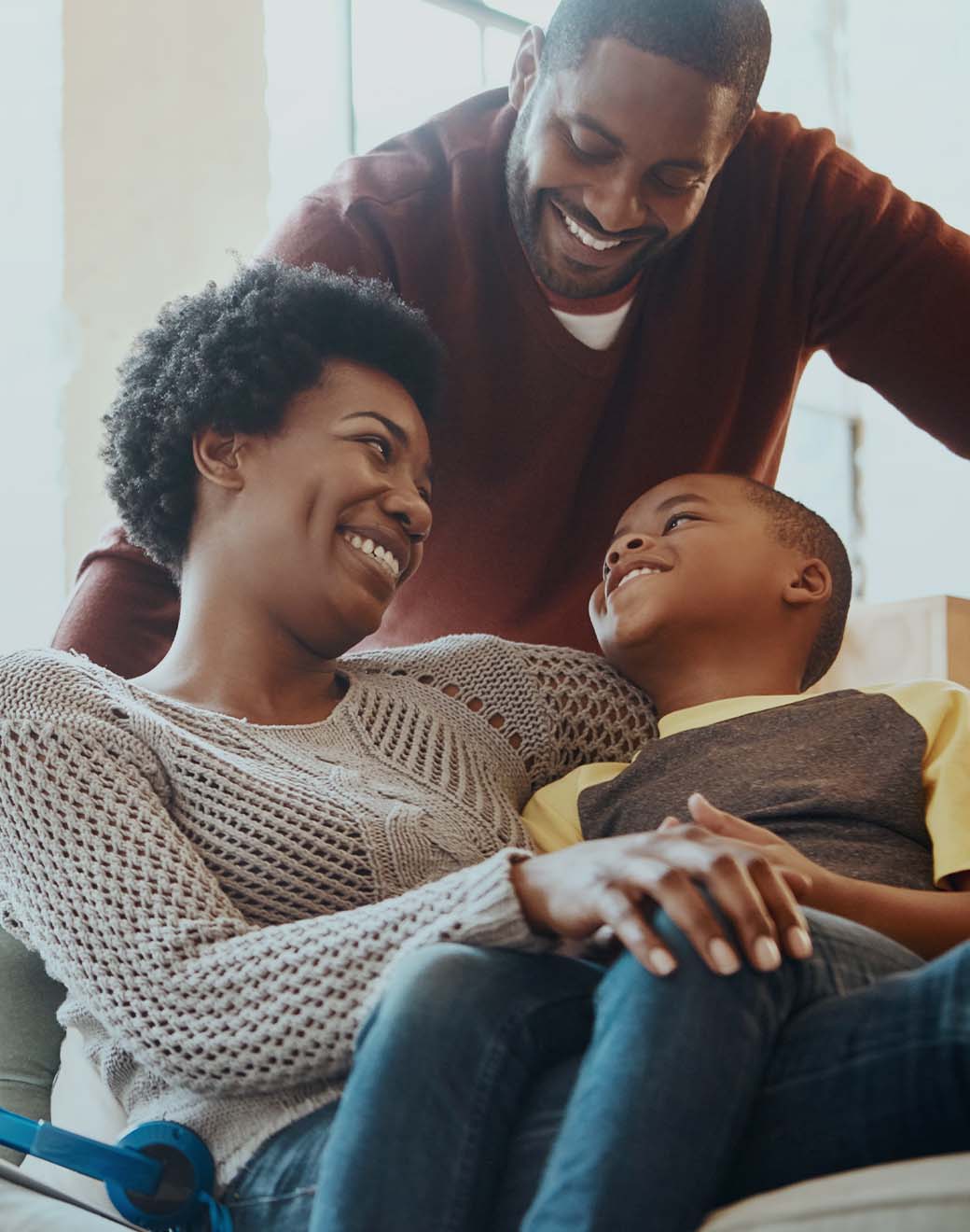 Family of three hang out together on the couch.