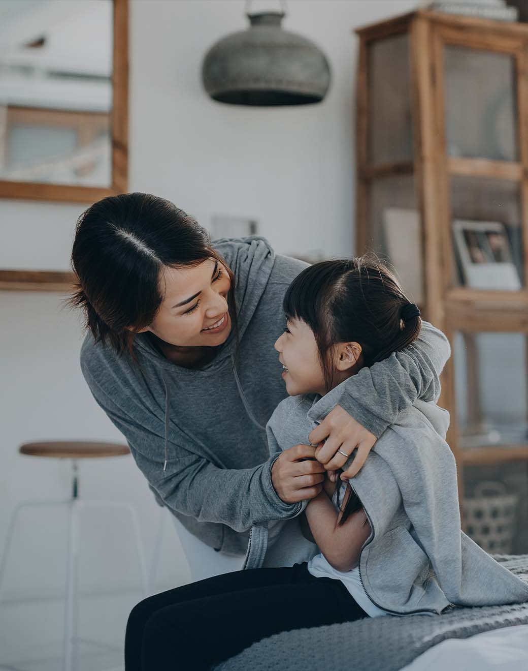 Mother and daughter hugging and smiling.