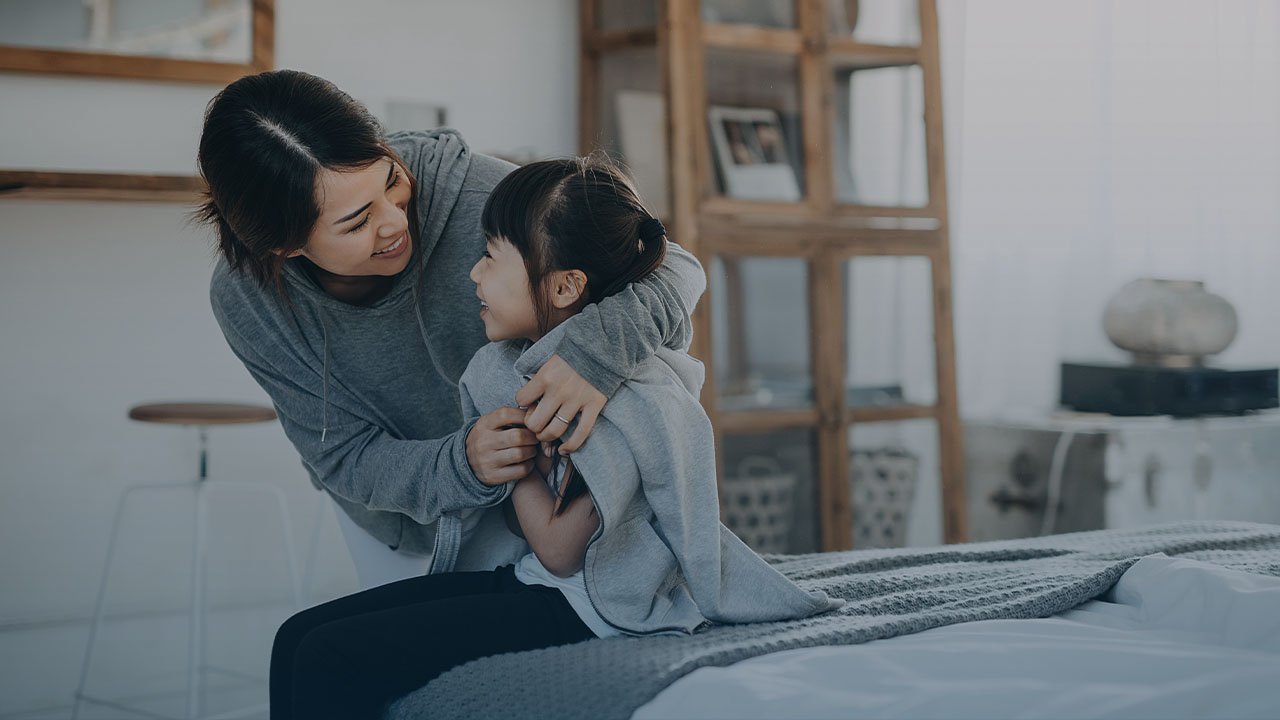 Mother and daughter hugging and smiling.