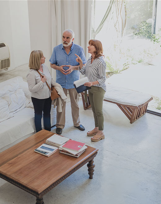 A real estate agent showing a home to an older couple.