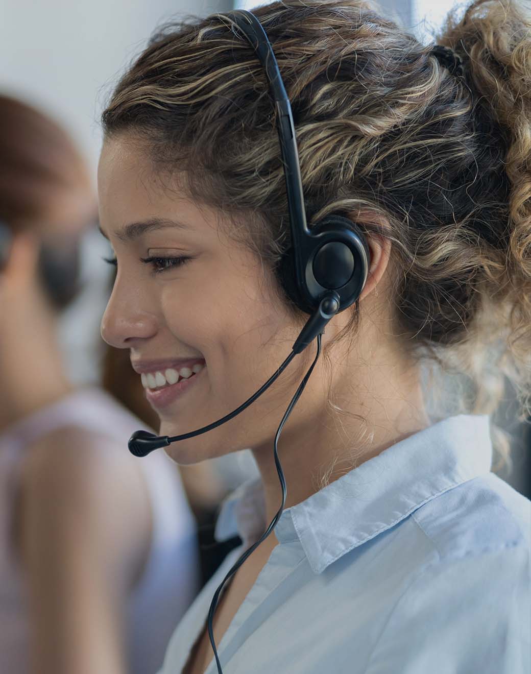 Young woman wearing a call headset and smiling. Young woman wearing a call headset and smiling.